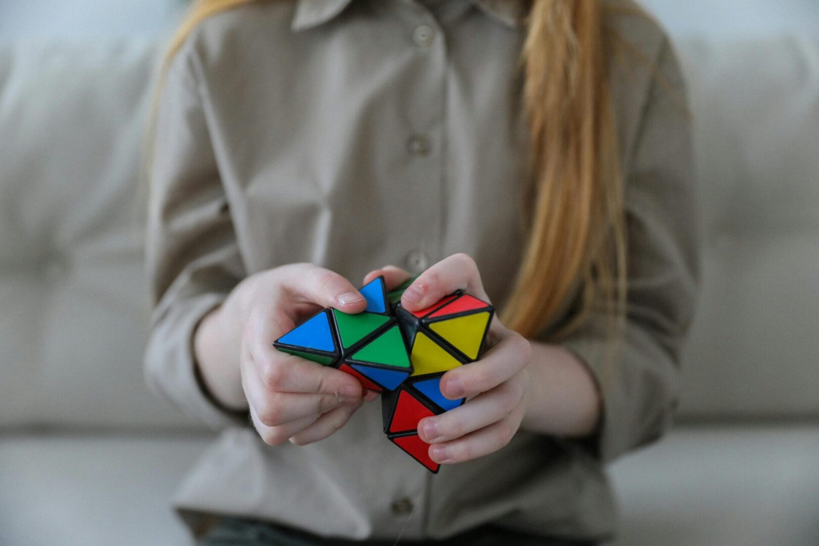 A girl holding a rubiks cube in her hands.